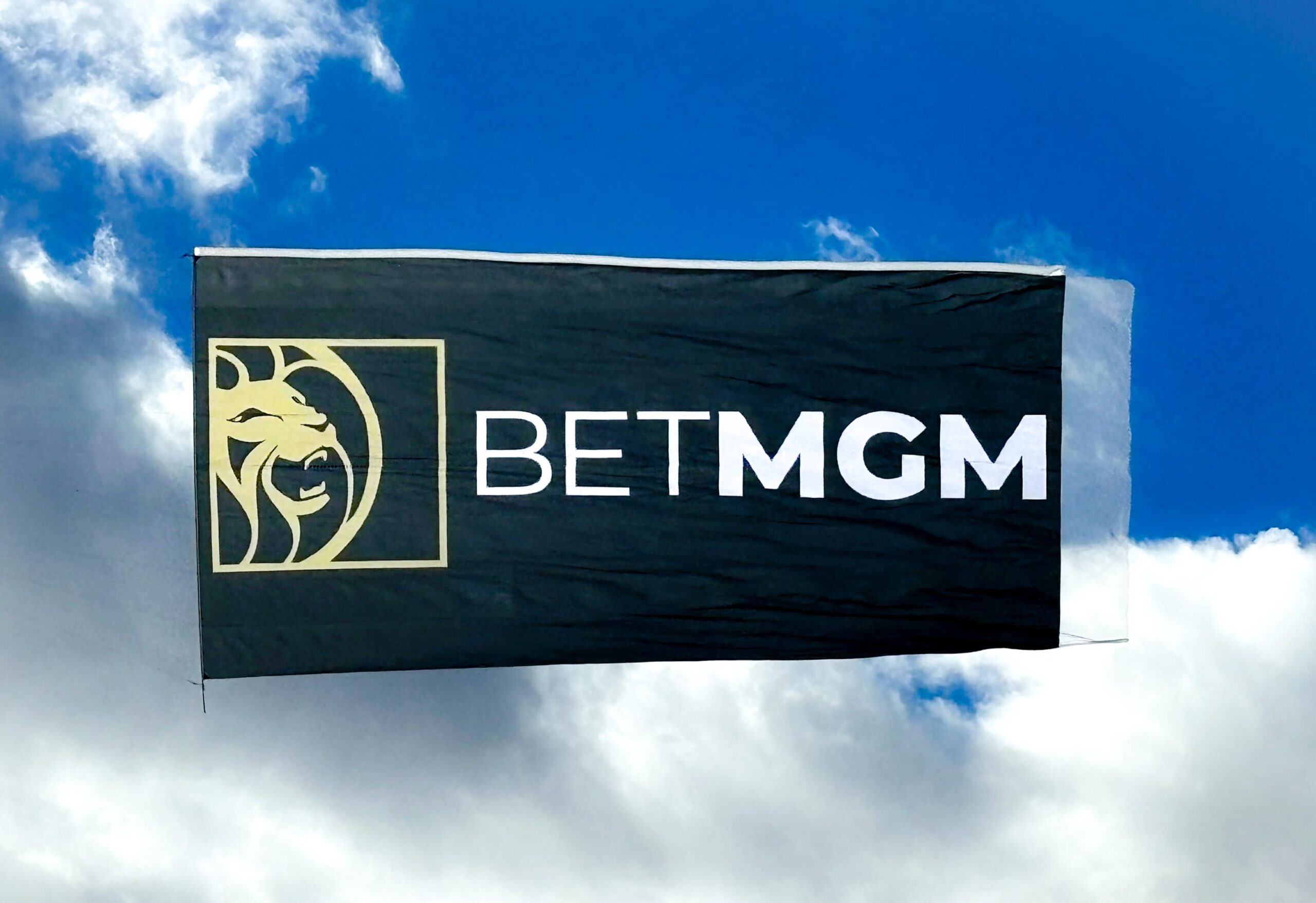 An image of a large aerial billboard soaring against a vibrant blue sky, prominently displaying the iconic BET MGM lion logo, symbolizing the brand's presence and allure in the entertainment and gaming industry.